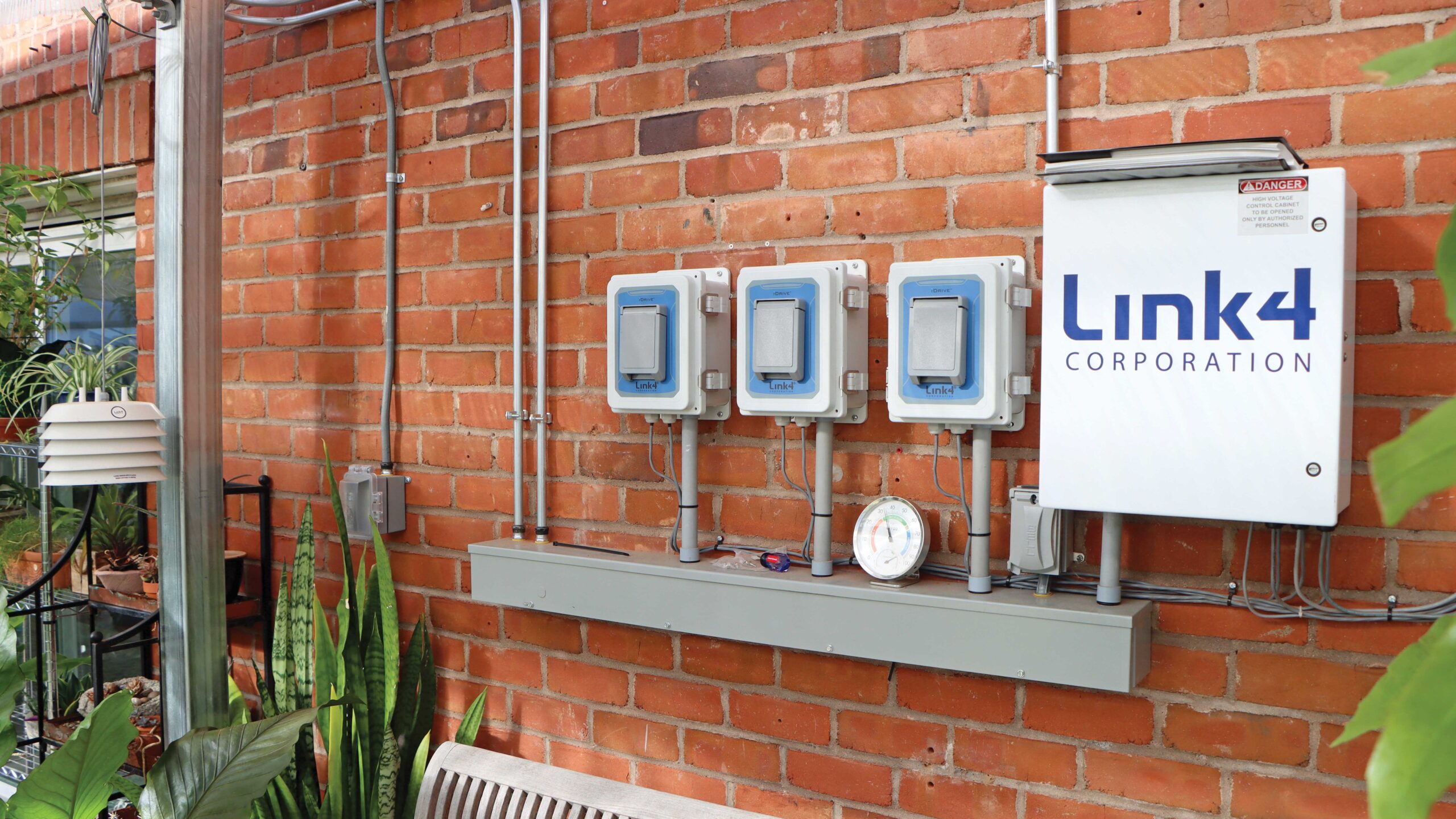 Link4 controllers mounted on brick wall inside greenhouse