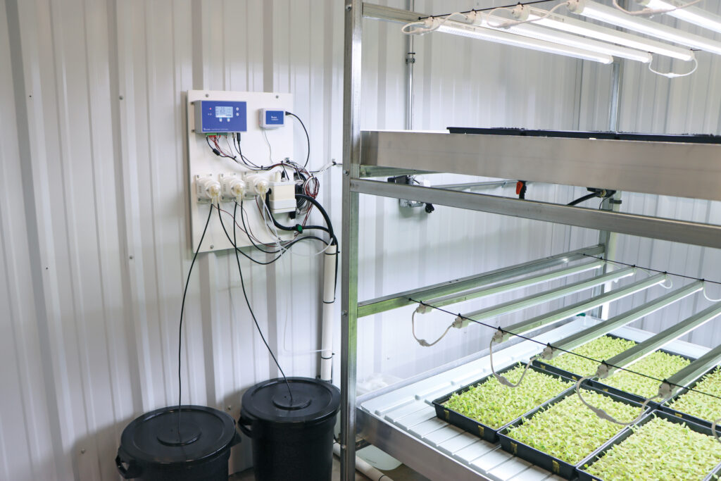Bluelab controller connected to nutrient buckets next to vertical growing system